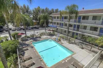 an overhead view of a swimming pool in front of a hotel at Motel 6-San Bernardino, CA - North in Serrano Village