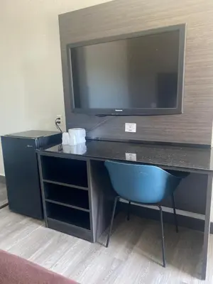 a desk with a television and a chair in a room at Motel 6-San Bernardino, CA - North in Serrano Village