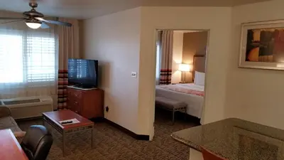 a hotel room with a bed and a television at Hawthorn Suites in Victorville