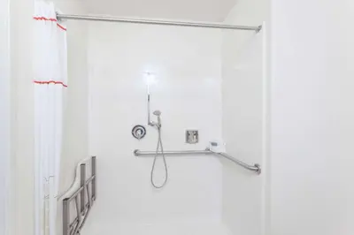 a shower in a bathroom with a shower curtain at Hawthorn Suites in Victorville