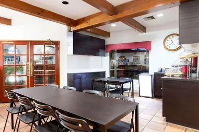a kitchen with tables and chairs and a clock on the wall at Days Inn by Wyndham Castaic Six Flags Magic Mountain in Castaic