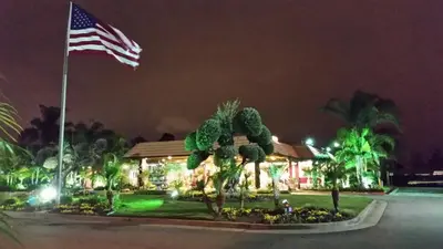 an american flag in front of a house at night at Ontario Airport Inn in Ontario