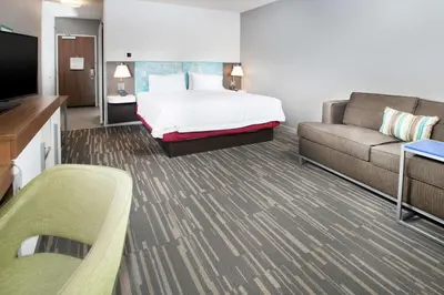 a hotel room with a bed and a couch at Hampton Inn Arvin Tejon Ranch, Ca in Wheeler Ridge