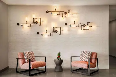 a room with two chairs and lights on a wall at La Quinta Inn & Suites by Wyndham San Bernardino in San Bernardino
