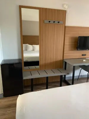 a bedroom with a mirror and a bed and a desk at Motel 6-Santa Ana, CA in Santa Ana