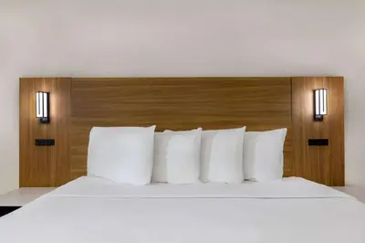 a bed with white pillows in a hotel room at Motel 6-Santa Ana, CA in Santa Ana