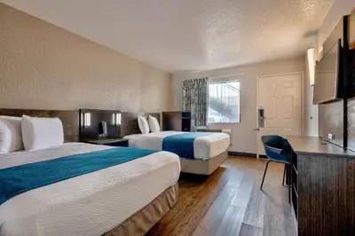 a hotel room with two beds and a desk at Motel 6-Anaheim, CA - Fullerton East in Anaheim
