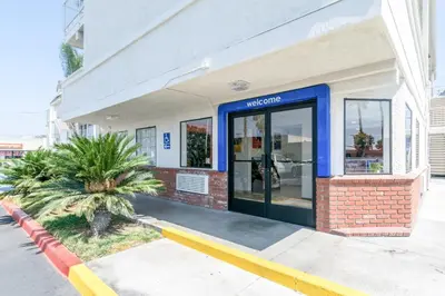a store front with a blue door on a street at Motel 6-Anaheim, CA - Fullerton East in Anaheim