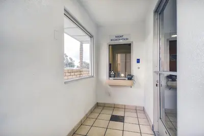 a hallway with a bathroom with a window and a mirror at Motel 6 Chino, CA - Los Angeles Ontario in Chino