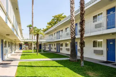 a courtyard of an apartment building with palm trees at Motel 6-Bakersfield, CA - East in Bakersfield