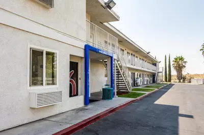 a building with a blue door and stairs on a street at Motel 6-Bakersfield, CA - East in Bakersfield