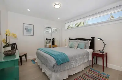 a bedroom with a bed and a desk and windows at Oasis with pool and music studio by BENVENU in Los Angeles