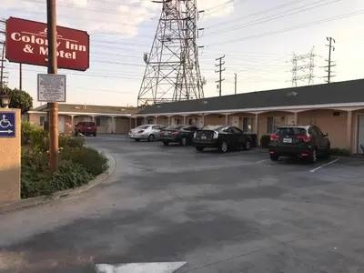 a parking lot with cars parked in front of a motel at Colony Inn Motel in Bellflower