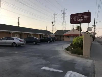 a sign for a country inn and motel in a parking lot at Colony Inn Motel in Bellflower