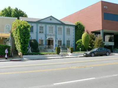 a car parked in front of a blue house at Hotel del Flores in Los Angeles