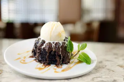 a chocolate dessert with a scoop of ice cream on a plate at Hilton Woodland Hills/ Los Angeles in Woodland Hills