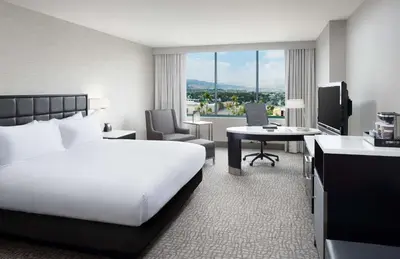 a hotel room with a large bed and a desk at Hilton Woodland Hills/ Los Angeles in Woodland Hills
