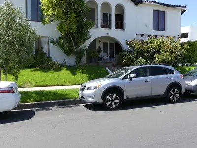 a white car parked in front of a white house at Wilshire Orange Hotel in Los Angeles