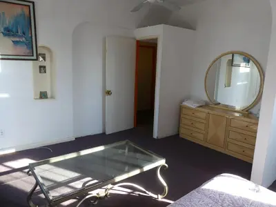 a room with a mirror and a dresser with a glass table at Wilshire Orange Hotel in Los Angeles