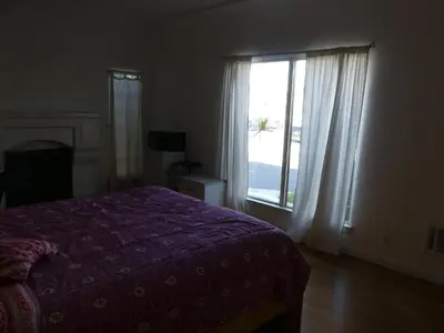 a bedroom with a bed and a large window at Wilshire Orange Hotel in Los Angeles