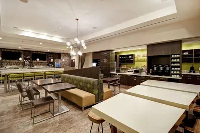 a restaurant with tables and chairs and a bar at Home2 Suites by Hilton Los Angeles Montebello in Montebello