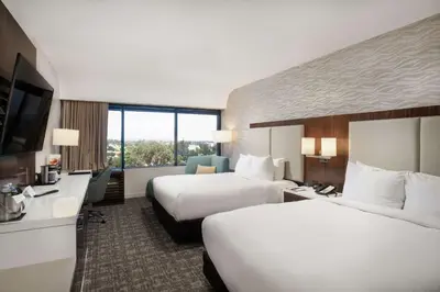 a hotel room with two beds and a flat screen tv at DoubleTree by Hilton Monrovia - Pasadena Area in Monrovia