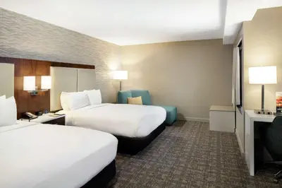 a hotel room with two beds and a chair at DoubleTree by Hilton Monrovia - Pasadena Area in Monrovia
