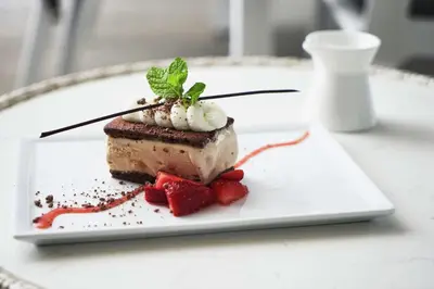 a piece of dessert on a white plate with strawberries at The Beverly Hilton in Los Angeles