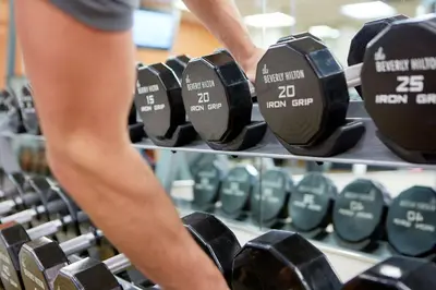 a person is looking at a rack of dumbbells at The Beverly Hilton in Los Angeles