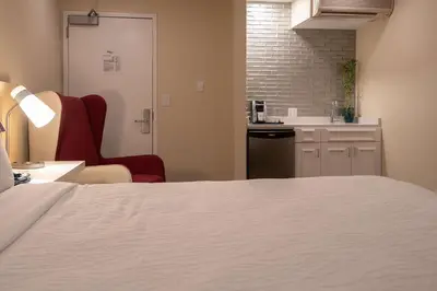 a room with a bed and a chair and a kitchen at Hilton Garden Inn Calabasas in Calabasas