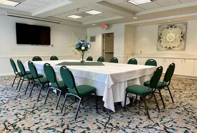 a conference room with a large table and green chairs at Hilton Garden Inn Calabasas in Calabasas