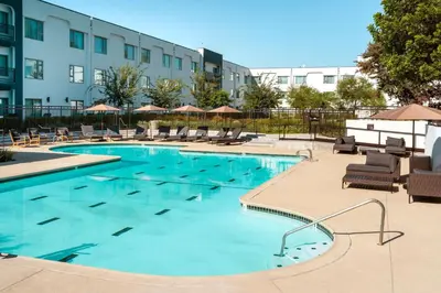 a large swimming pool with chairs and a building at Delta Hotels by Marriott Ontario Airport in Ontario