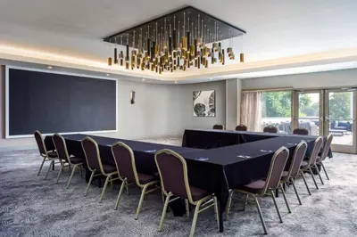 a conference room with a large black table and chairs at Delta Hotels by Marriott Ontario Airport in Ontario