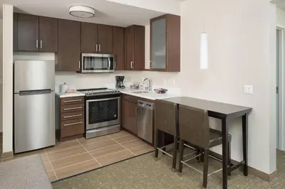 a kitchen with wooden cabinets and a black counter top at Residence Inn by Marriott Ontario Rancho Cucamonga in Rancho Cucamonga