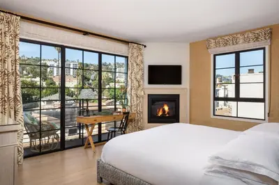 a bedroom with a bed and a fireplace and a desk at Hotel 850 SVB, West Hollywood, a Member of Design Hotels in Los Angeles