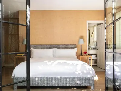 a bedroom with a bed with white sheets at Hotel 850 SVB, West Hollywood, a Member of Design Hotels in Los Angeles