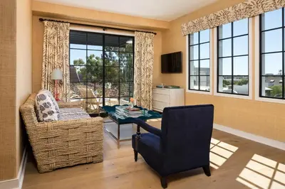 a living room with a table and a chair and windows at Hotel 850 SVB, West Hollywood, a Member of Design Hotels in Los Angeles