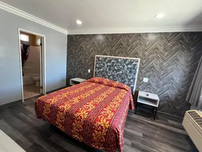 a bedroom with a large bed with a red blanket at Harbor Inn in Harbor City