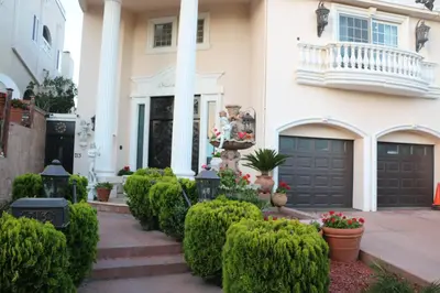 a house with a gate and bushes at Entire Second Flr - Santa Monica Luxury Roman Villa in Los Angeles
