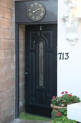 a black door with a clock on top of it at Entire Second Flr - Santa Monica Luxury Roman Villa in Los Angeles
