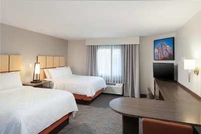 a hotel room with two beds and a table at Candlewood Suites Anaheim - Resort Area by IHG in Anaheim
