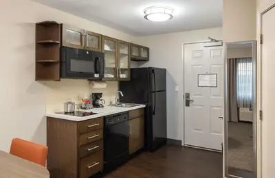 a small kitchen with a sink and a refrigerator at Candlewood Suites Anaheim - Resort Area by IHG in Anaheim
