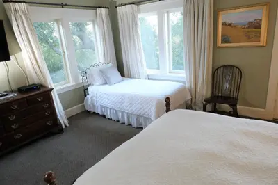 a bedroom with two beds and two windows at Arroyo Vista Inn in Los Angeles