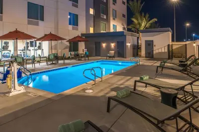 a swimming pool at night with tables and chairs at TownePlace Suites by Marriott Ontario Chino Hills in Chino Hills