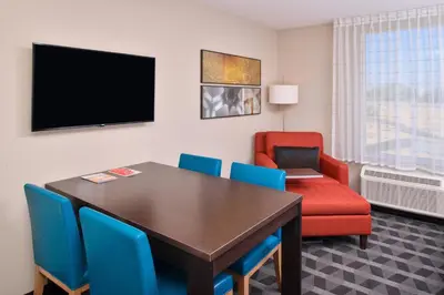 a dining room with a table and chairs and a television at TownePlace Suites by Marriott Ontario Chino Hills in Chino Hills