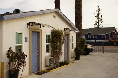 a building with a blue door on a street at Route 66 Motel - Rialto in Rialto