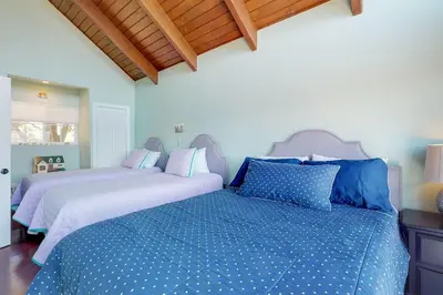 two beds with blue and white sheets in a bedroom at Mountain Top Chalet in Lake Arrowhead