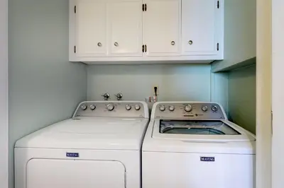 a kitchen with a stove and a washer and dryer at Mountain Top Chalet in Lake Arrowhead