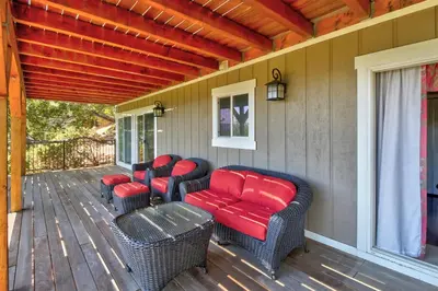 a porch with wicker chairs and red cushions at Mountain Top Chalet in Lake Arrowhead