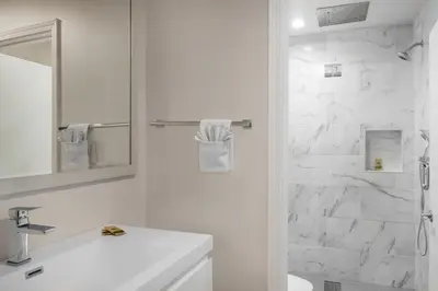 a white bathroom with a sink and a shower at Route 66 Motel in Barstow